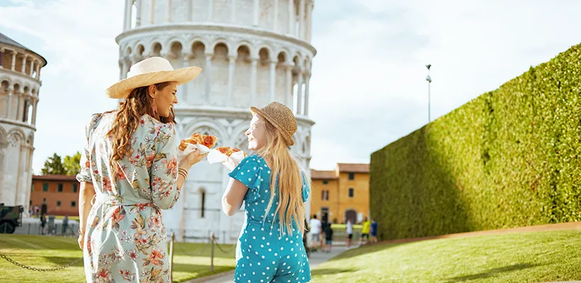 Jeune fille et mère heureuse avec une pizza dans les mains près de la Tour de Pise, en Italie